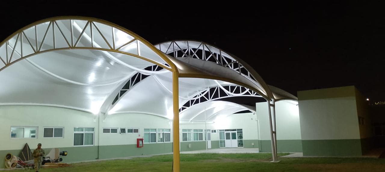 Vista nocturna de un proyecto de tensoestructuras iluminado.