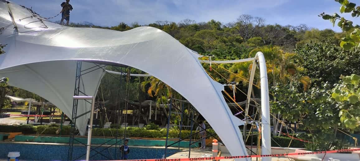 Panorámica de la cubierta para alberca, protegiendo del sol a los nadadores.