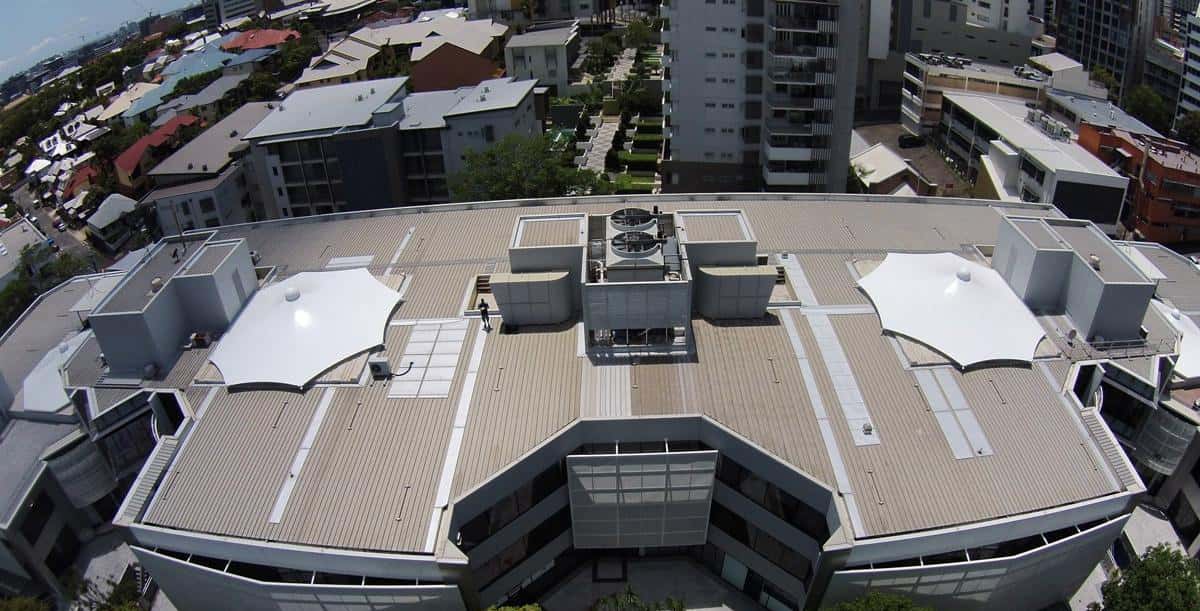 Diseño de múltiples velarias cónicas creando un espacio cubierto y ventilado.