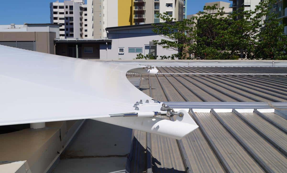 Espacio comercial al aire libre protegido por una elegante velaria cónica.