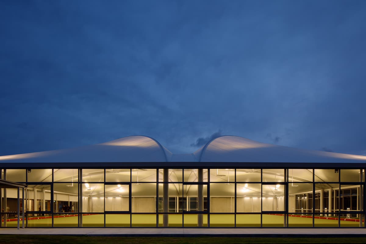 Tensoestructura brindando sombra a las bancas de un área de descanso en un parque.